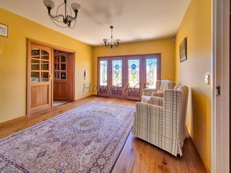 Welcoming entrance hall featuring warm hardwood flooring, decorative stained glass doors, and classic timber finishes, creating a bright and inviting transition space.