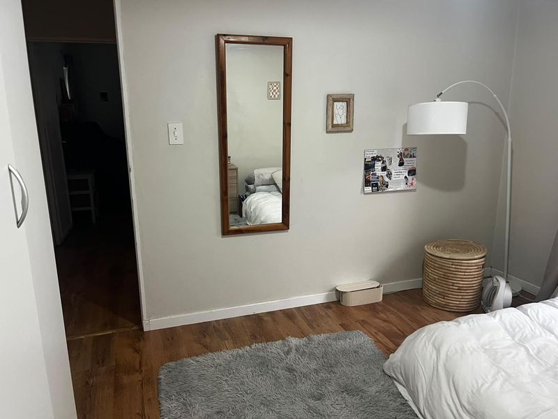 A bedroom featuring laminate flooring and a built-in wardrobe, providing a functional and neutral living space.