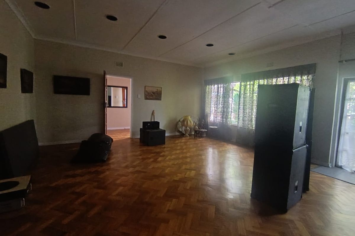 Spacious living area featuring classic parquet flooring, recessed ceiling lighting, and coved cornicing, offering a versatile layout for various interior design configurations.
