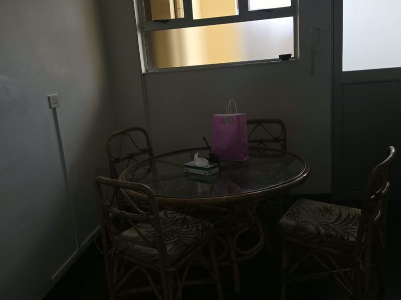 A dining area featuring a window and door, providing basic functional space for meals.