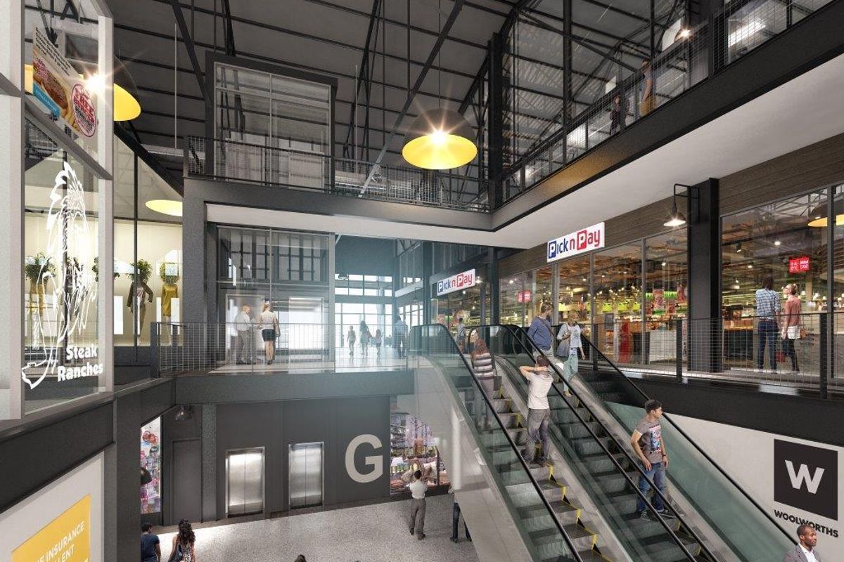 Modern multi-level retail shopping center interior featuring escalators, glass-fronted storefronts, and an open-plan atrium design with industrial architectural elements.