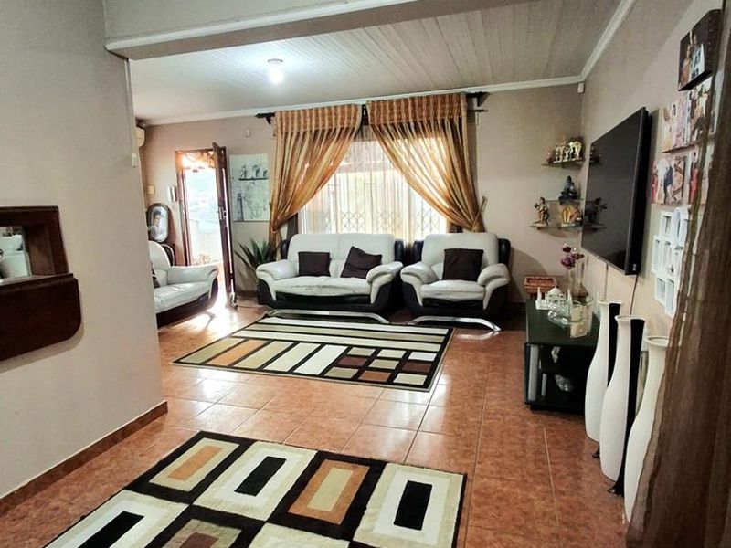 Spacious living area featuring tiled flooring and a timber panel ceiling, providing a functional and comfortable space for relaxation.