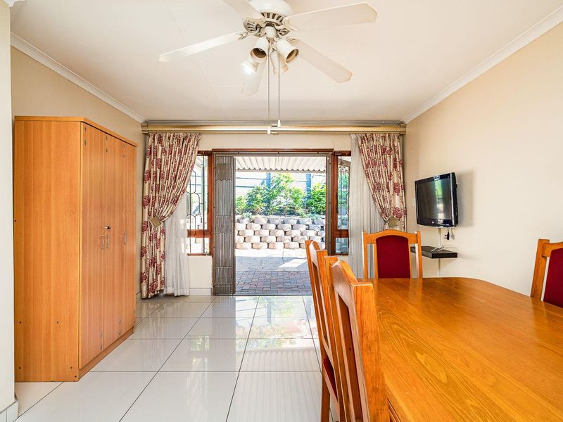 Dining area featuring tiled flooring, a ceiling fan, and direct access to an outdoor patio through sliding glass doors.