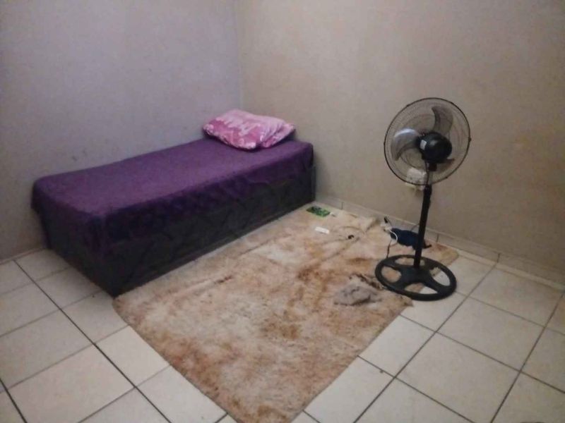 A simple bedroom featuring tiled flooring and plain wall finishes, offering a basic layout ready for personalization.