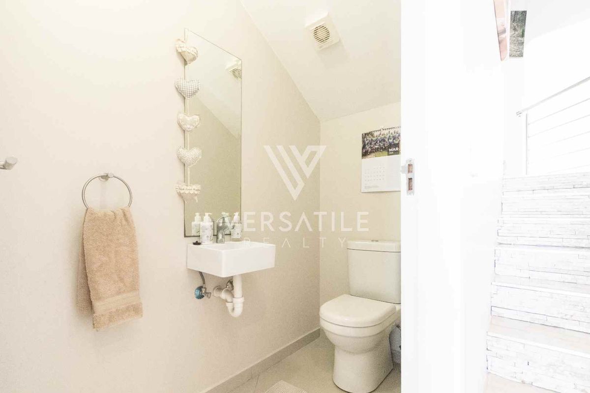 A compact guest powder room featuring a wall-mounted basin, toilet, and extractor fan.
