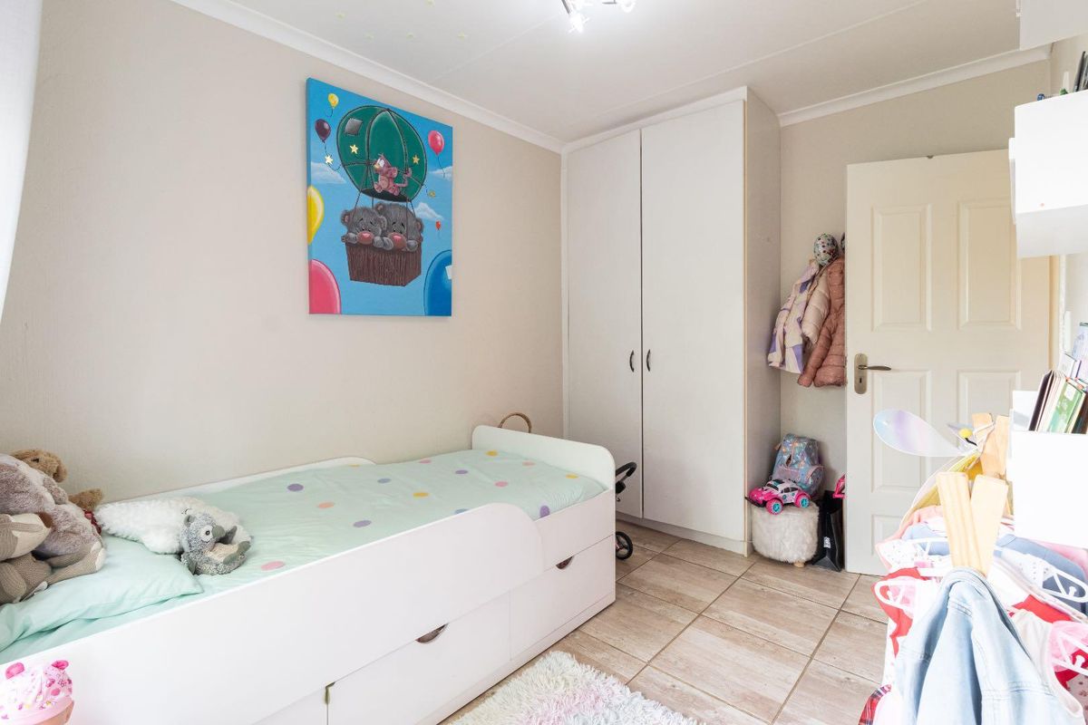 A bedroom featuring built-in cupboards and tiled flooring, providing functional storage space.