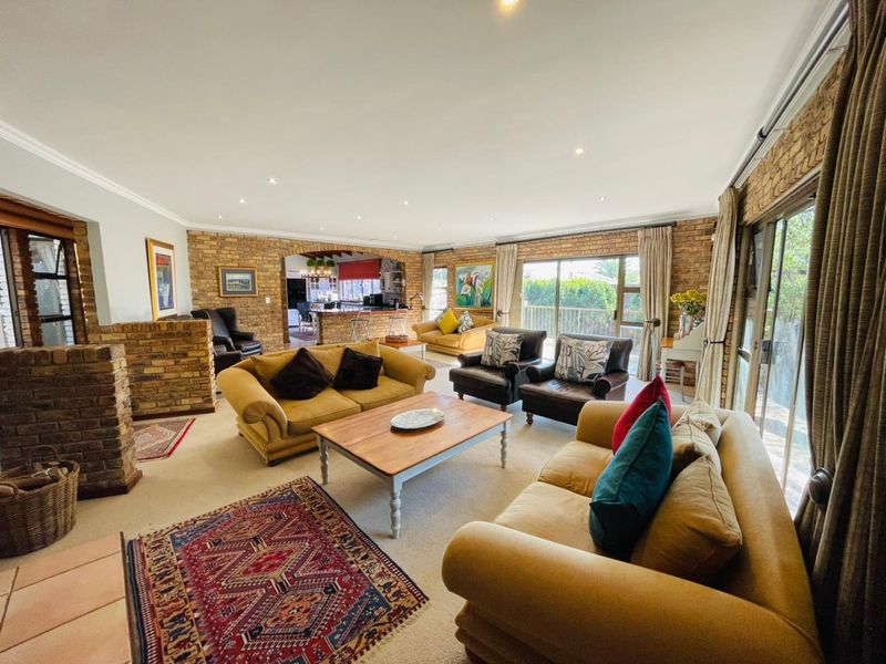 Spacious open-plan living area featuring exposed brick walls, a brick fireplace, and large sliding glass doors leading to the exterior.
