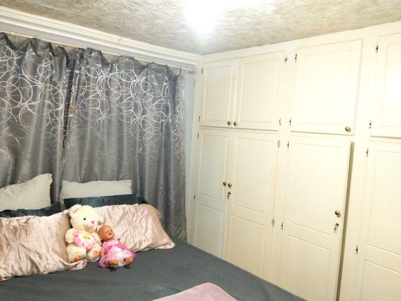 A bedroom featuring extensive floor-to-ceiling built-in cabinetry and decorative ceiling finishes.