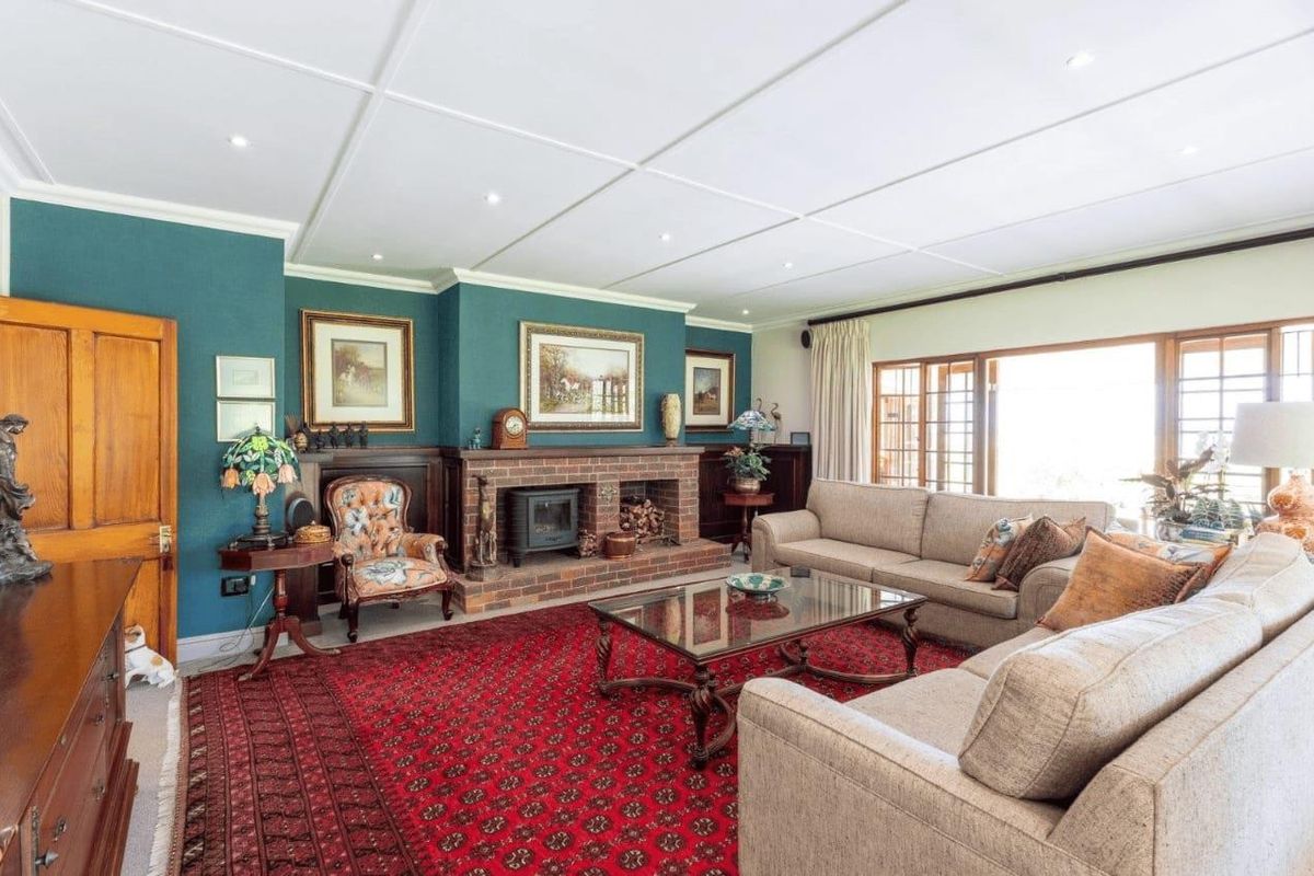 Spacious living room featuring a brick fireplace, wood-paneled wainscoting, and large sliding glass doors providing access to the outdoor area.