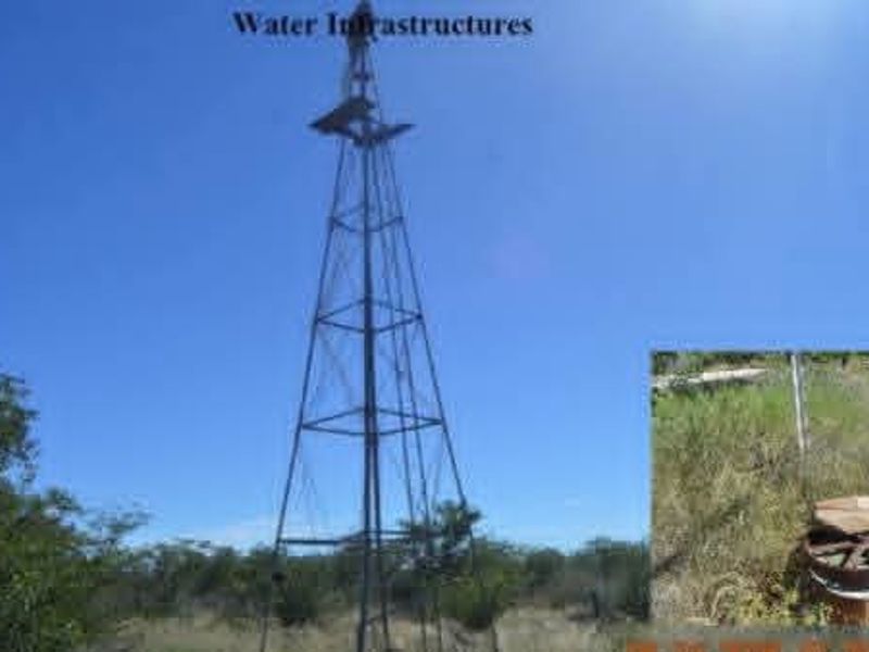 Farm water infrastructure featuring a traditional windmill and borehole setup for irrigation and livestock water supply.