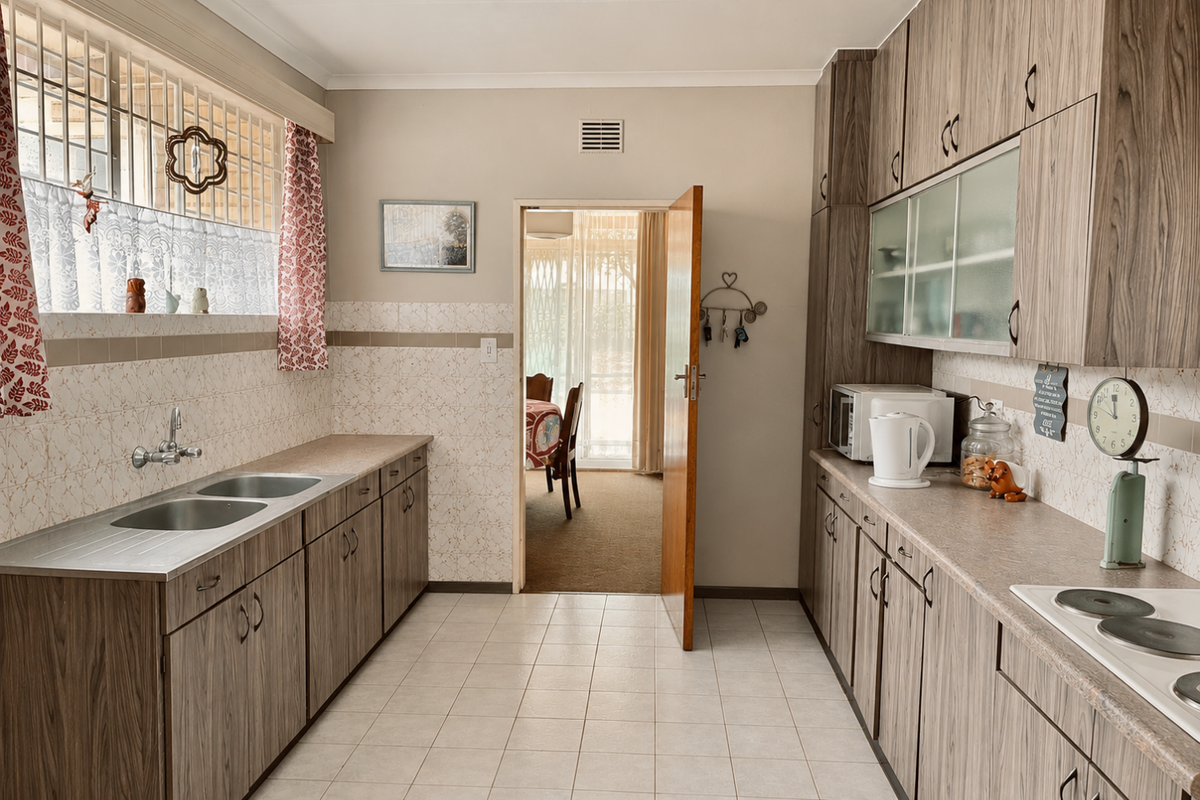 A functional kitchen featuring wood-look laminate cabinetry, a double stainless steel sink, tiled splashbacks, and an integrated electric hob.