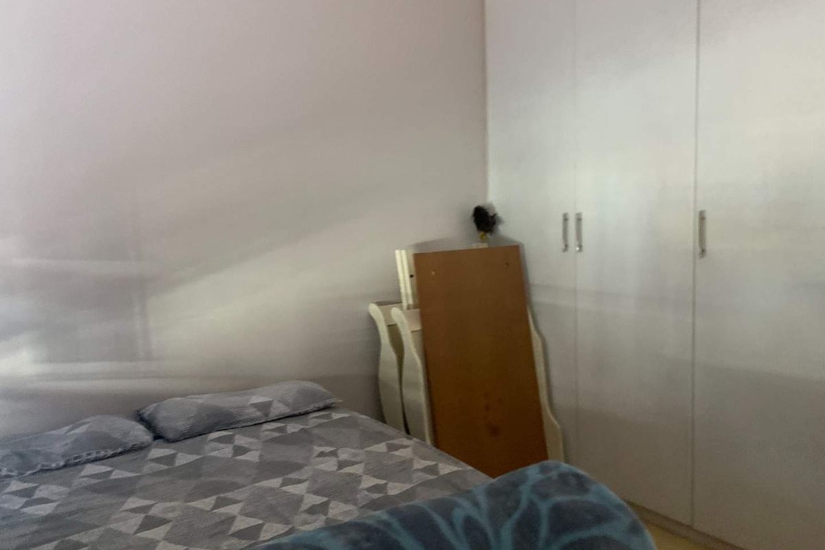 A bedroom featuring built-in white wardrobes providing ample storage space.
