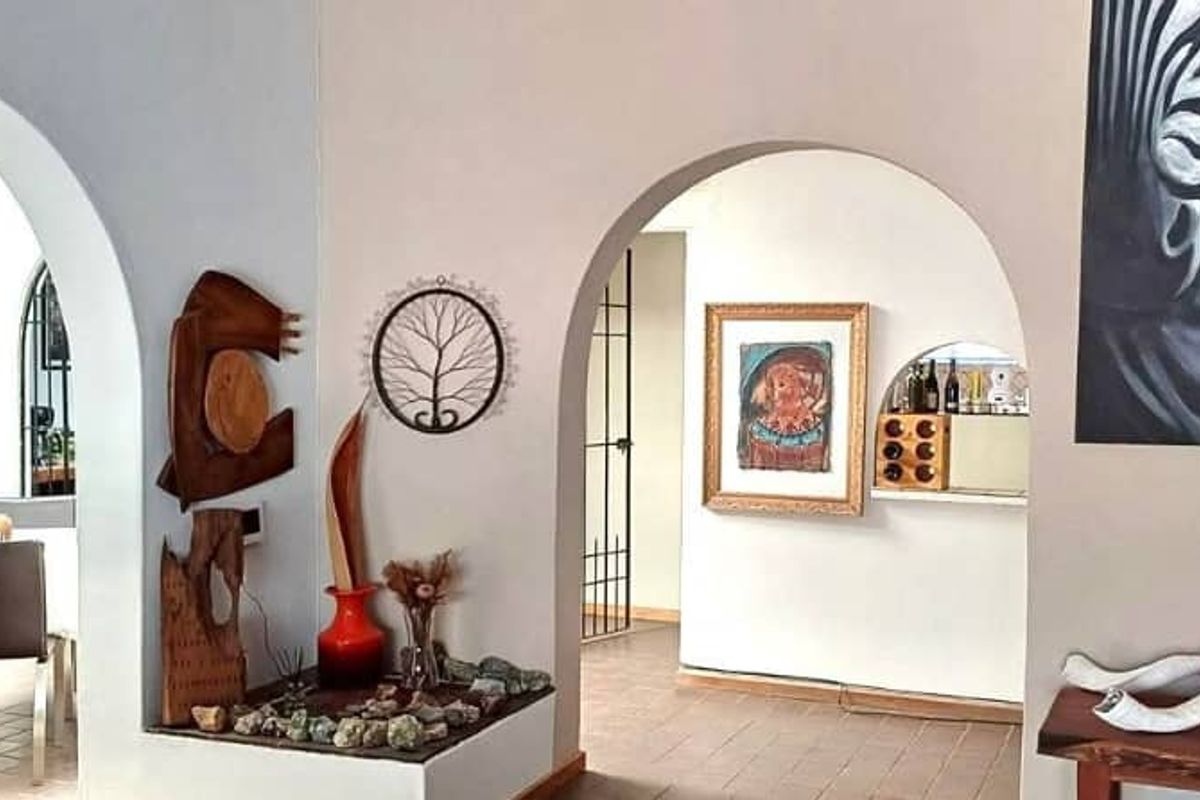 Interior view featuring arched doorways connecting living and dining areas with tiled flooring and neutral wall finishes.