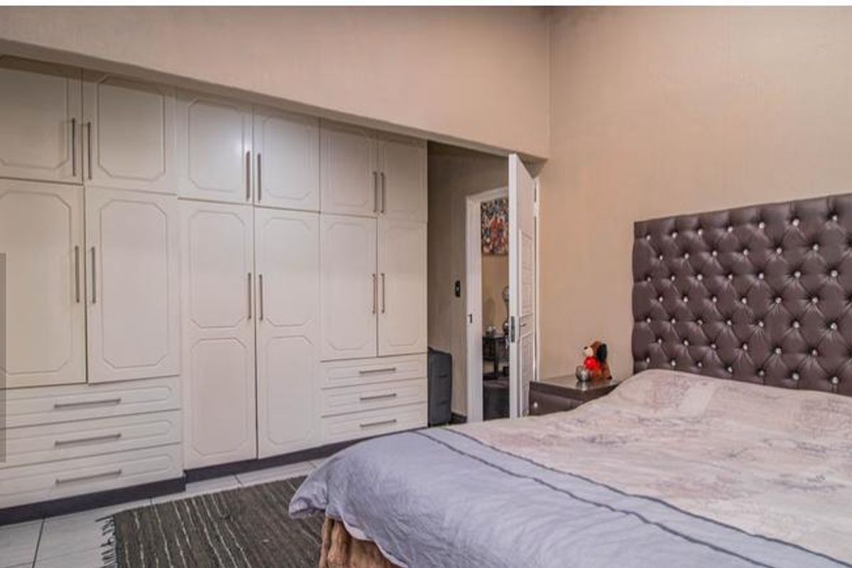 A bedroom featuring extensive built-in cabinetry with integrated drawers and storage, providing ample space for organization.