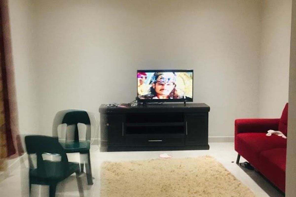 A simple living room featuring tiled flooring and recessed ceiling lighting.