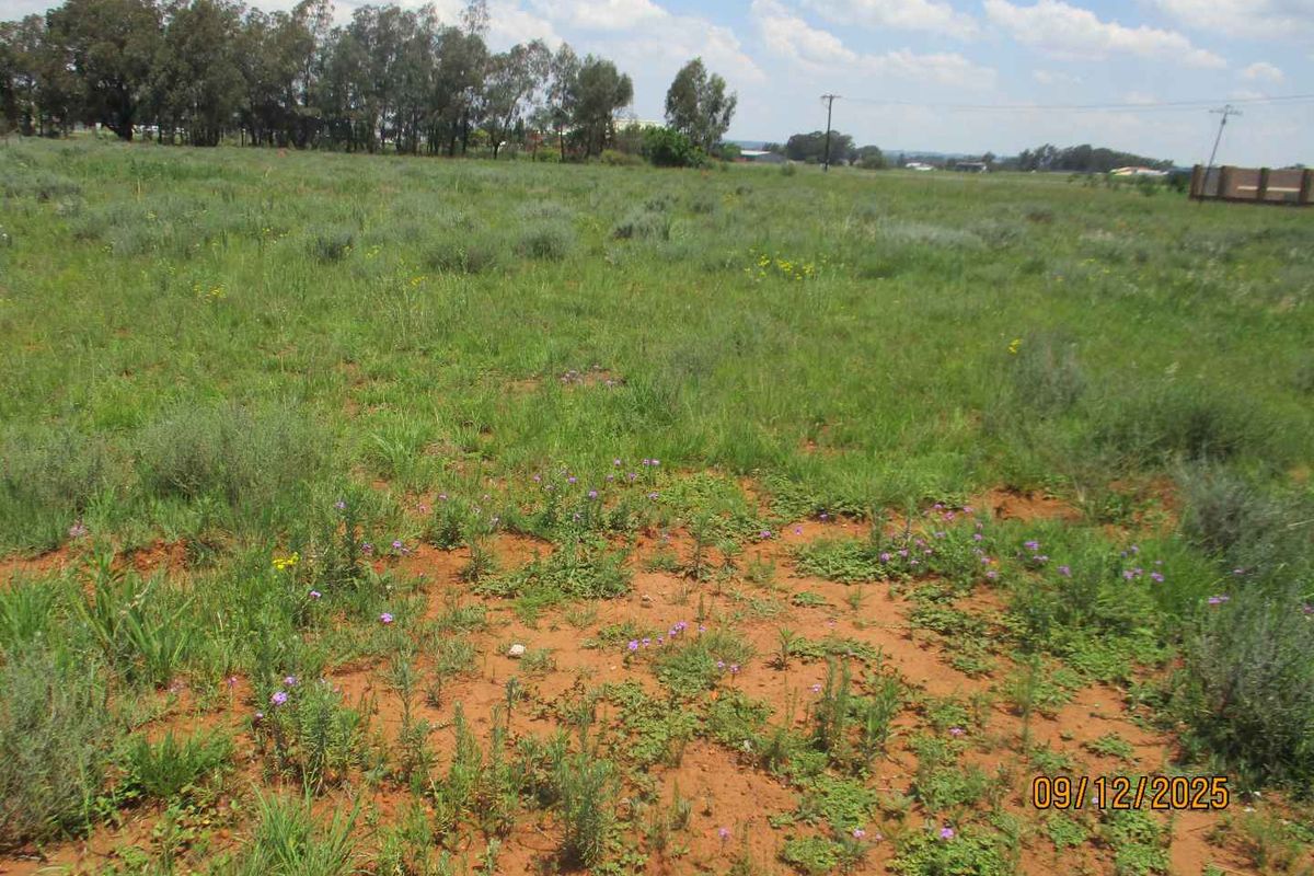 A view of a vacant residential plot featuring natural grass and soil, suitable for future development.