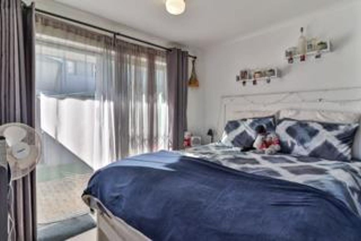 A bedroom featuring a large sliding glass door that provides natural light and direct access to an outdoor area.