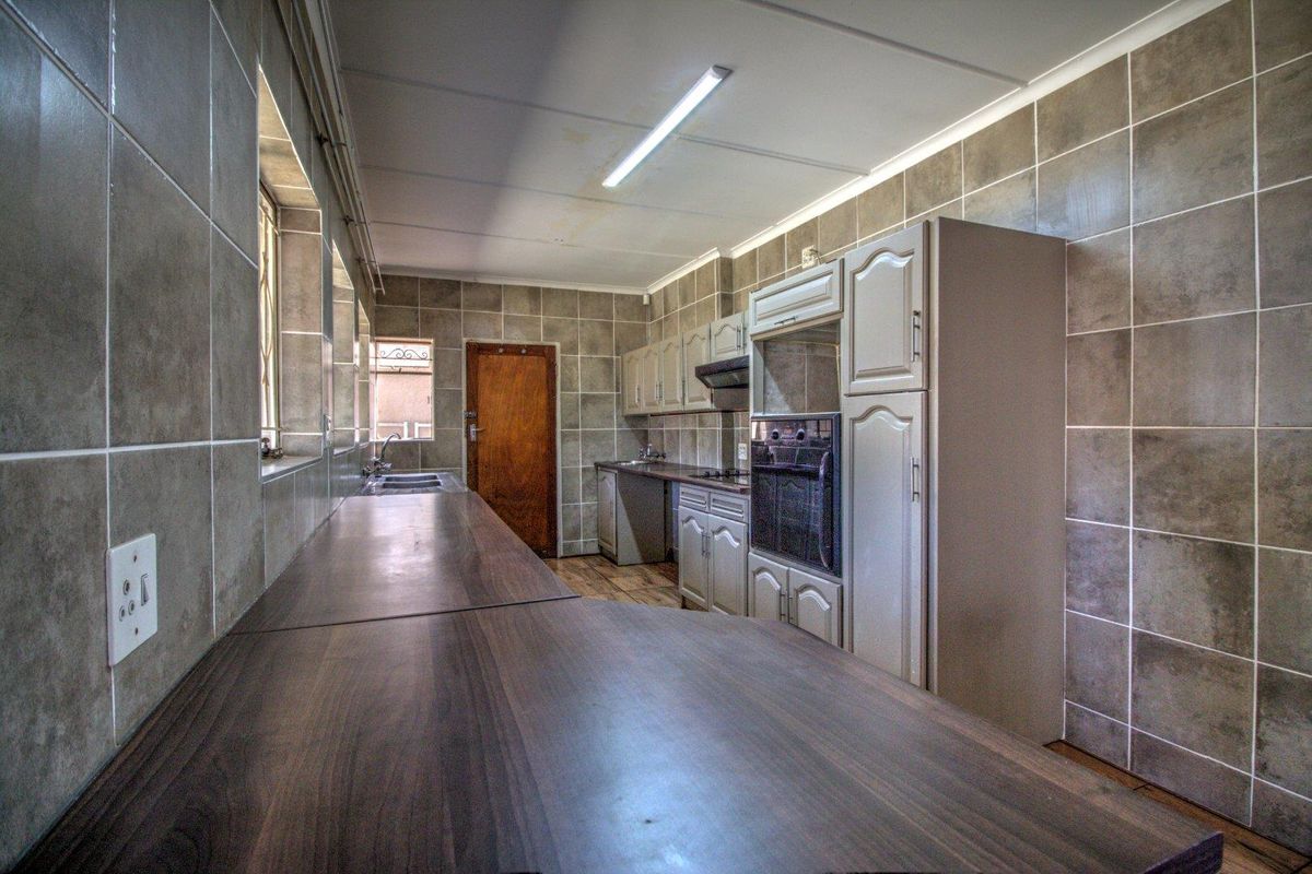 A functional kitchen featuring built-in cabinetry, laminate countertops, a built-in oven, and tiled wall finishes throughout.
