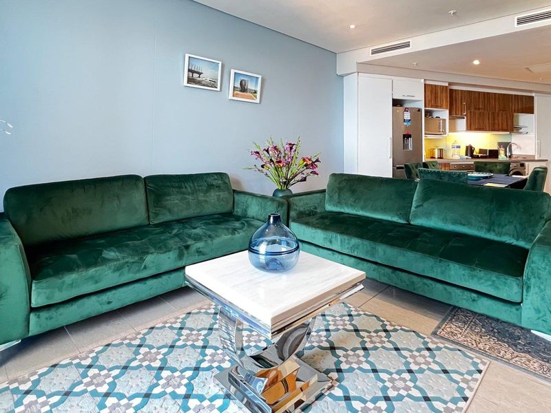 An open-plan living area featuring modern finishes, recessed lighting, ducted air conditioning, and a seamless transition into a well-appointed kitchen space.
