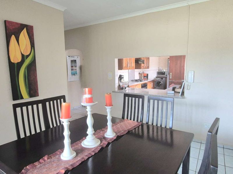 Dining room featuring tiled flooring and a convenient serving hatch connecting to the kitchen area.