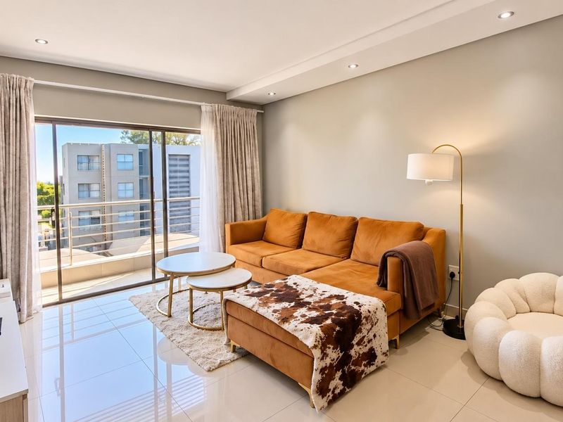 A bright and modern living room featuring large sliding glass doors that open onto a balcony, complemented by polished tiled flooring and recessed ceiling lighting.
