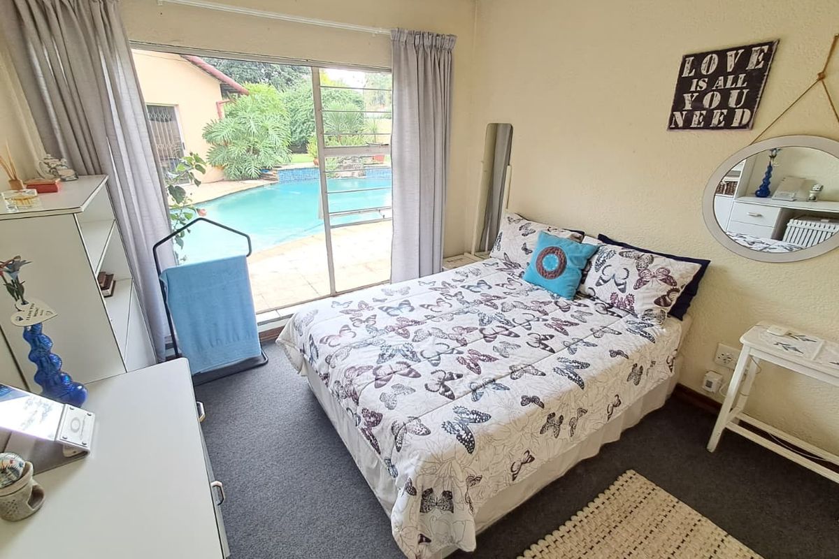 A bedroom featuring large sliding glass doors that provide direct access to the outdoor pool area.
