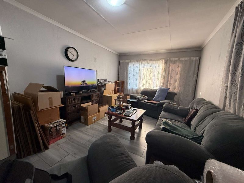 A living room featuring tiled flooring and neutral wall finishes, providing a functional space for relaxation.