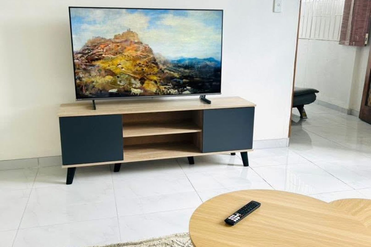 A bright living room area featuring neutral tiled flooring and clean wall finishes, providing a simple and functional space.