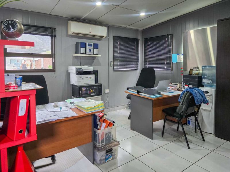 A functional office space featuring tiled flooring, split-system air conditioning, and venetian blinds, providing a practical work environment.