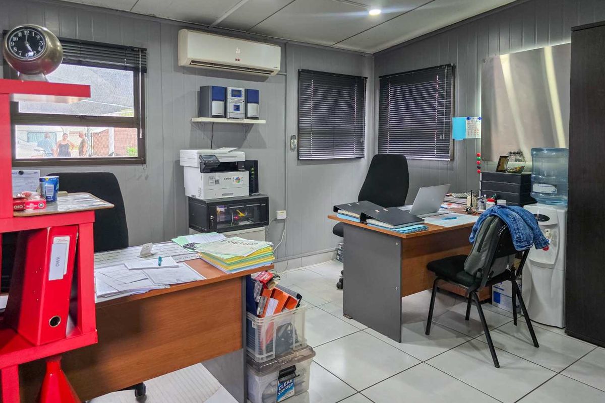 A functional office space featuring tiled flooring, split-system air conditioning, and venetian blinds, providing a practical work environment.