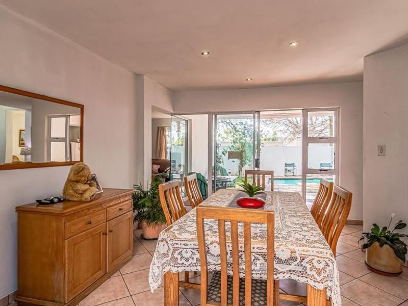 Dining room featuring tiled flooring and sliding glass doors that provide direct access to the outdoor pool area.