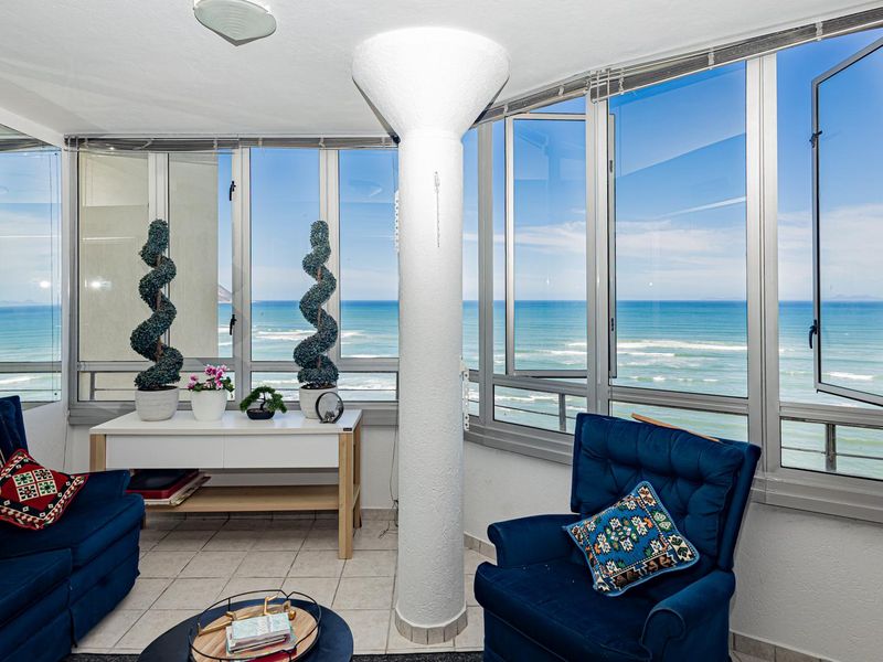 Enclosed balcony area featuring expansive ocean views, large glass windows, and tiled flooring, providing a bright and airy space.