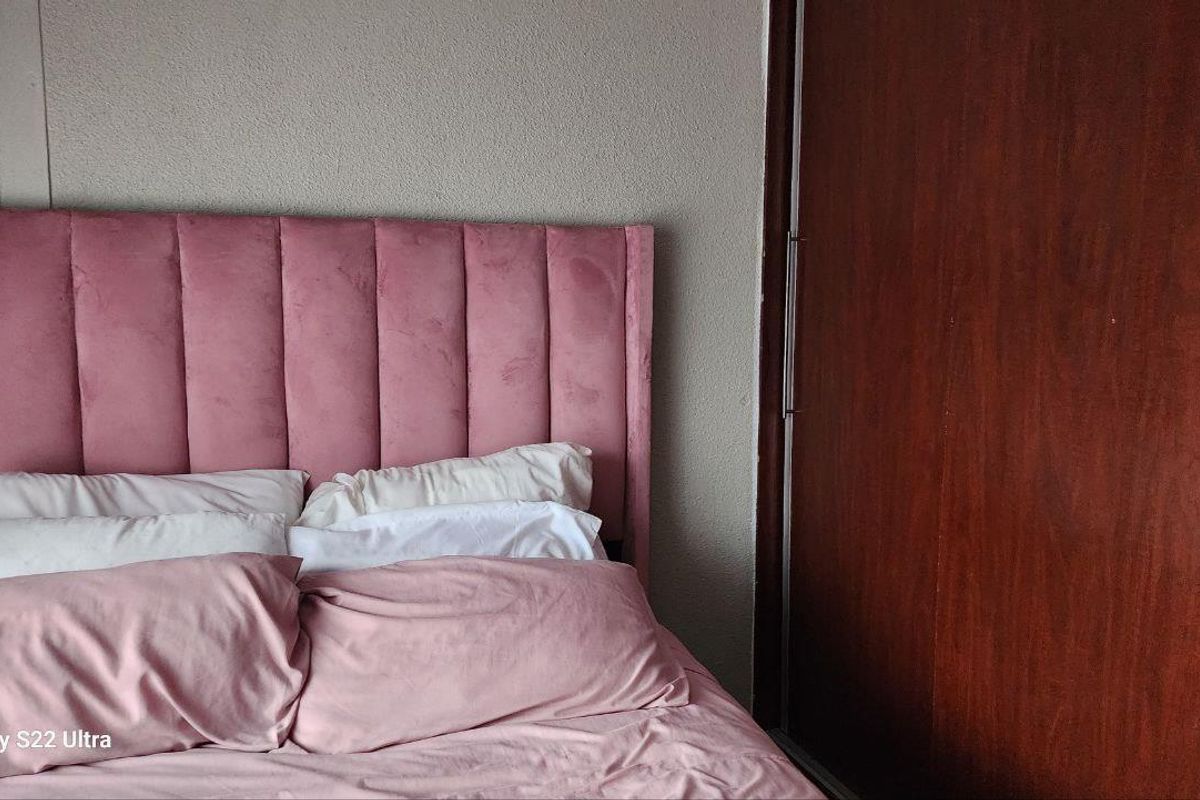 A bedroom featuring a built-in wooden wardrobe with sliding doors and neutral wall finishes.