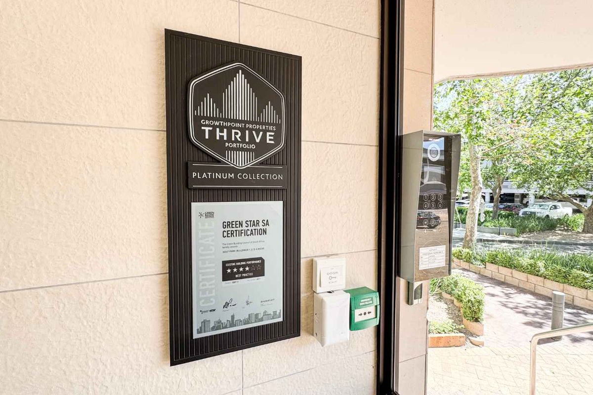 Entrance area featuring building certification signage, intercom system, and access control infrastructure.