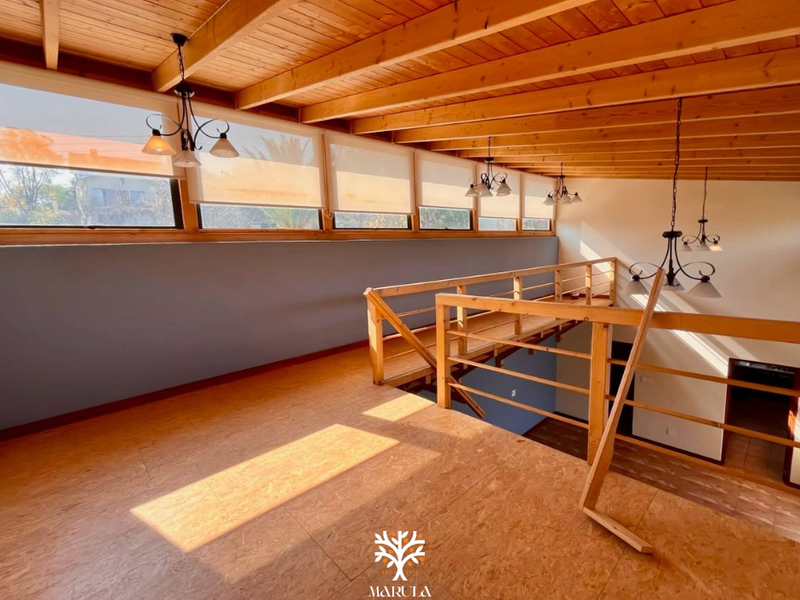 Spacious mezzanine level featuring exposed timber beam ceilings, timber flooring, and a timber balustrade overlooking the lower living area.
