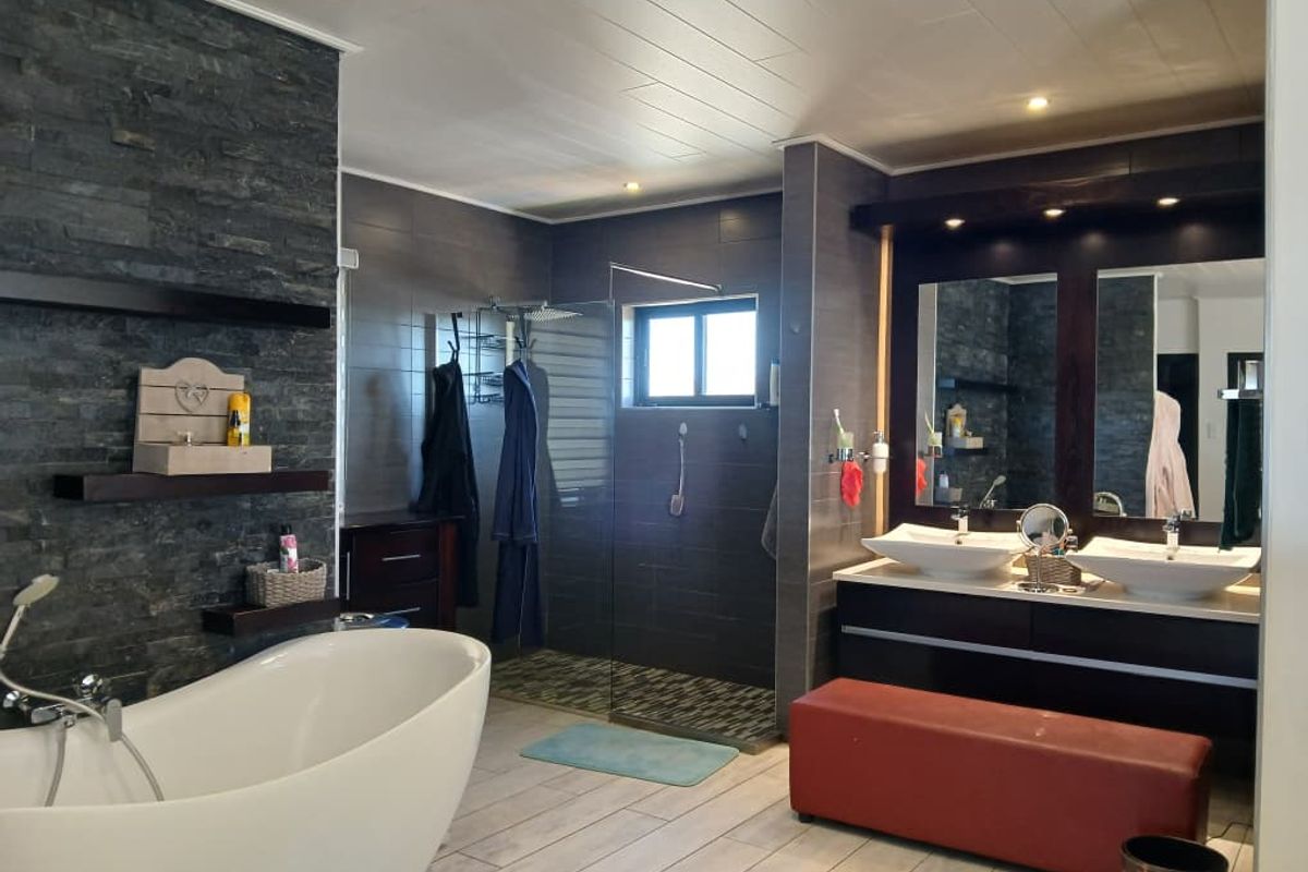 Modern bathroom featuring a freestanding soaking tub, a spacious walk-in shower with glass enclosure, and a double vanity with vessel sinks.