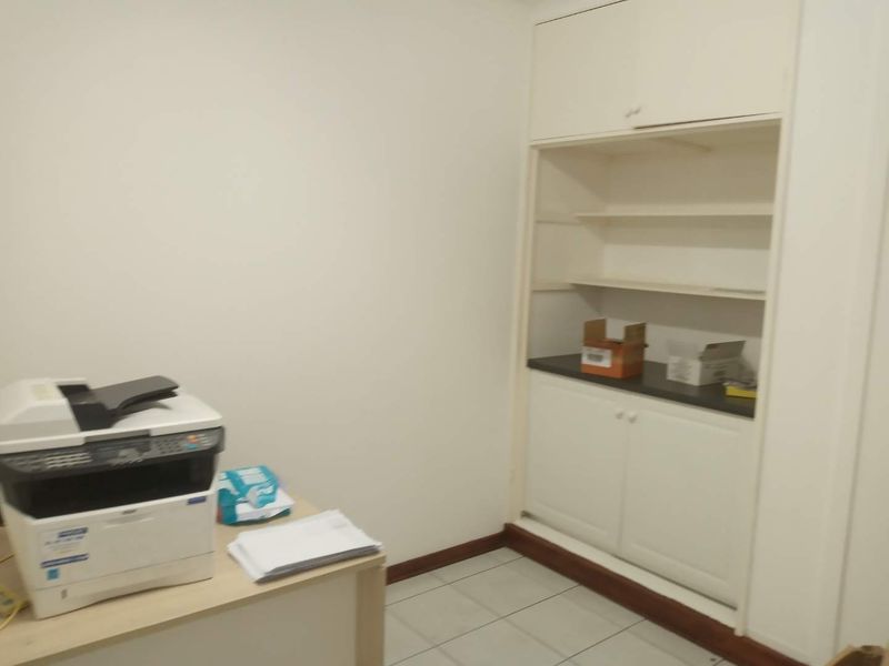 A functional office space featuring built-in storage cabinetry and tiled flooring, providing a clean and practical work environment.
