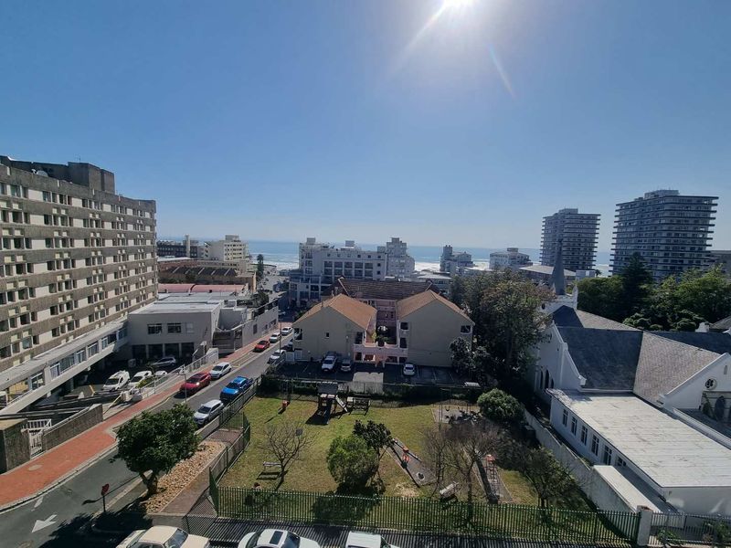 Elevated urban and coastal view overlooking the surrounding neighborhood, streetscape, and distant ocean horizon.