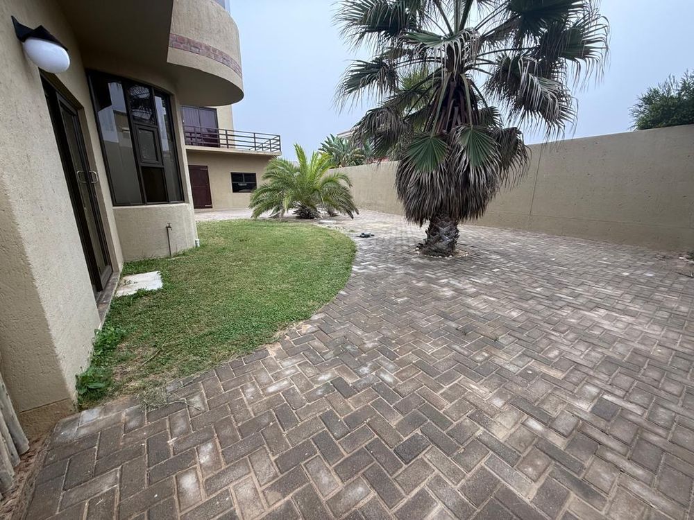 Front yard view. Carport spaces entering through a side gate