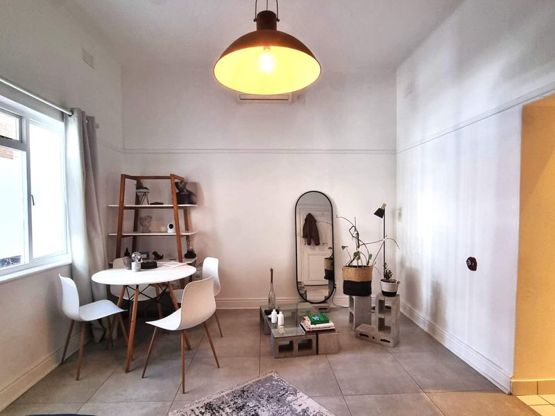 Open plan living and dining area featuring tiled flooring, high ceilings with picture rails, and a split system air conditioner.