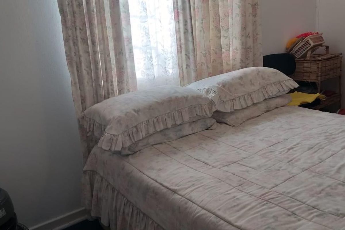 A bedroom featuring a window with curtains, providing a functional space for rest.