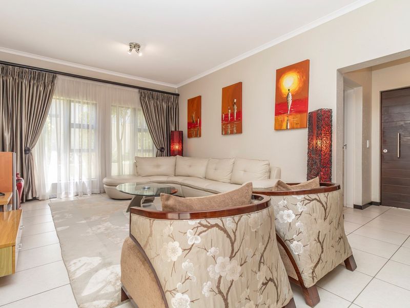 A bright and spacious living room featuring tiled flooring, large sliding glass doors for natural light, and modern recessed ceiling lighting.