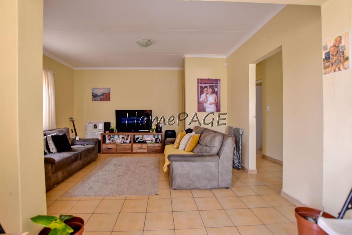 A spacious living room featuring neutral wall tones and tiled flooring, providing a functional and comfortable area for relaxation.