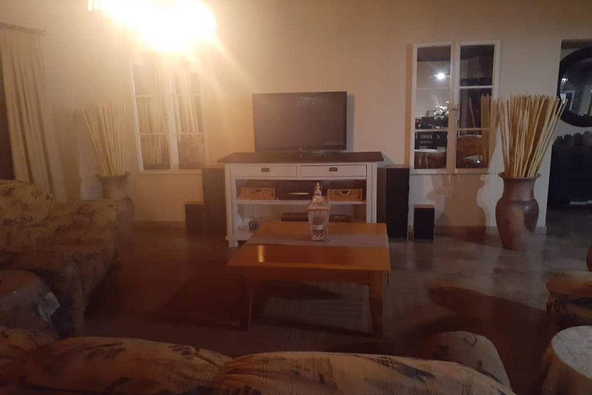 A cozy living room featuring tiled flooring and dual windows, providing a comfortable space for relaxation and entertainment.
