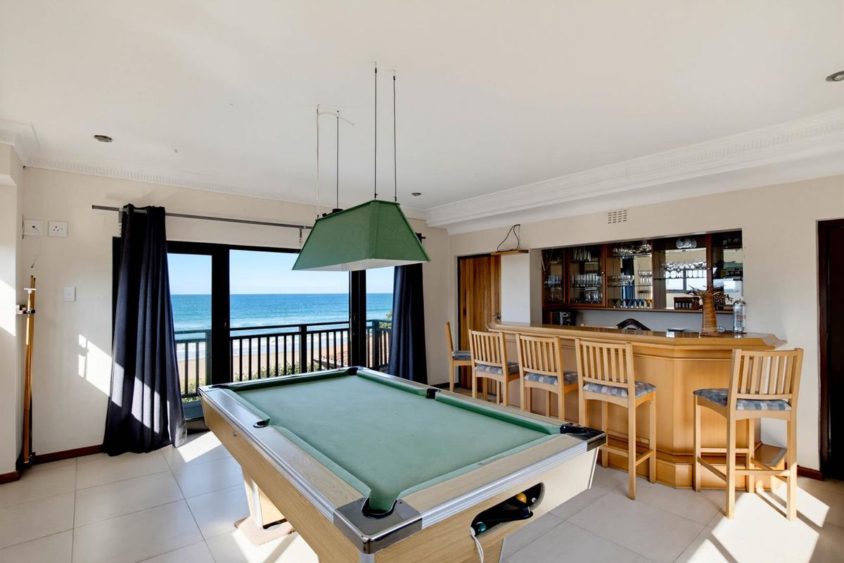 Entertainment room featuring a built-in bar with shelving and direct access to a balcony with ocean views.