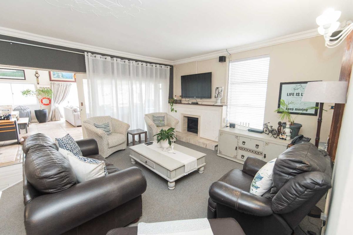 Spacious living room featuring a built-in fireplace, carpeted flooring, and large sliding doors providing access to an adjoining patio area.