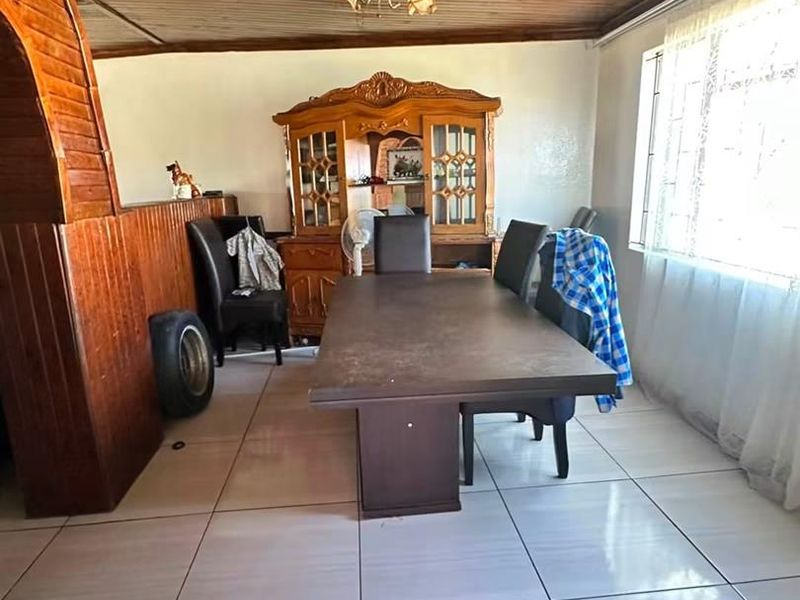 Dining room featuring ceramic floor tiles and a timber-clad ceiling, offering a dated aesthetic with potential for modernization.
