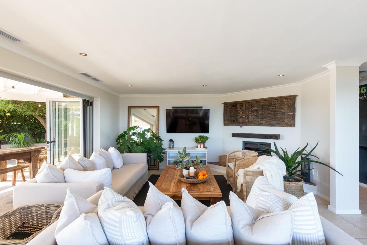 Spacious living room featuring a fireplace, recessed lighting, and large bi-fold doors that provide seamless access to the outdoor patio area.