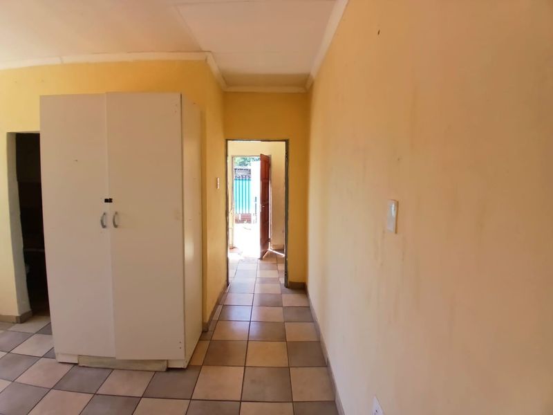 A functional hallway featuring tiled flooring and coved ceilings, providing a direct transition between interior spaces and the exterior entrance.