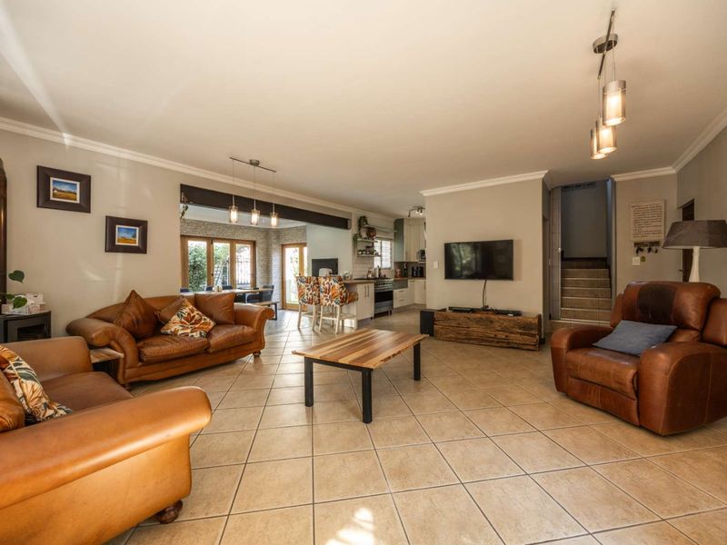 Spacious open-plan living area featuring tiled floors, a wood-burning stove, and a seamless transition into the kitchen and dining space.